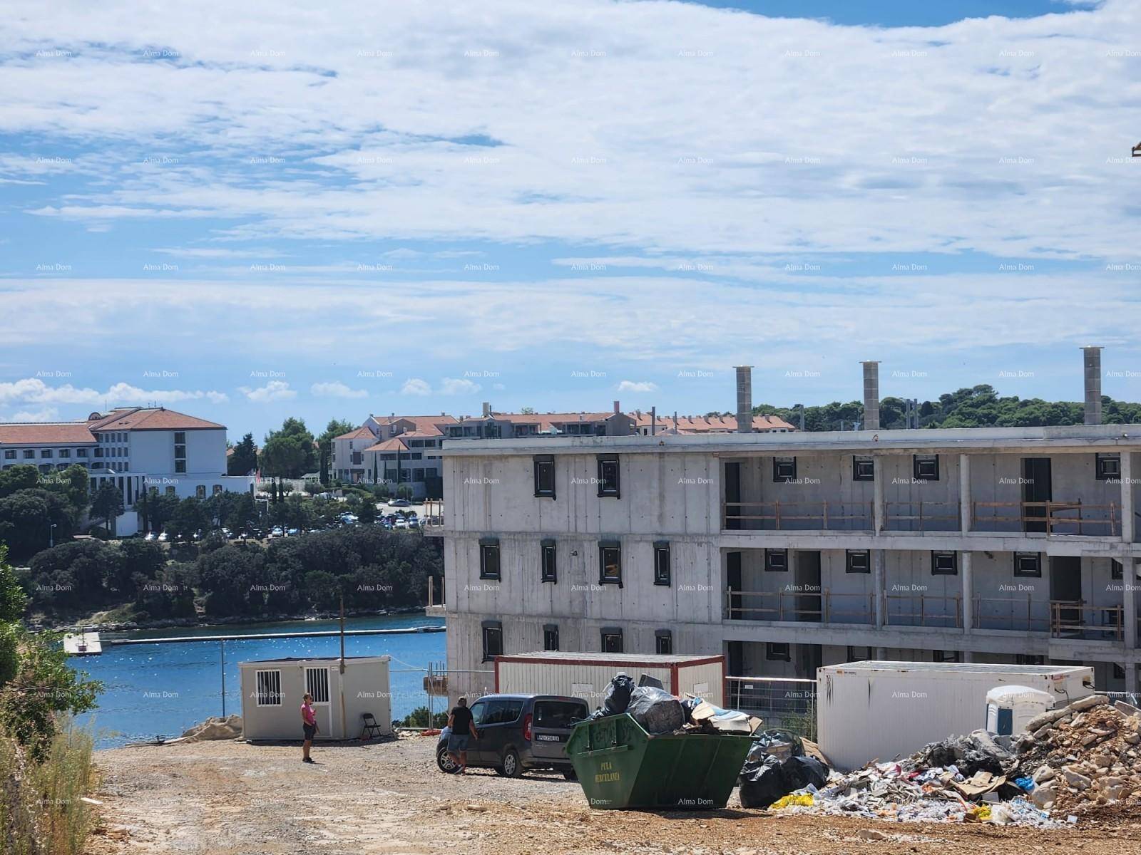Baustelle mit unfertigen Gebäuden und Blick auf das Meer, im Vordergrund ein Müllcontainer.