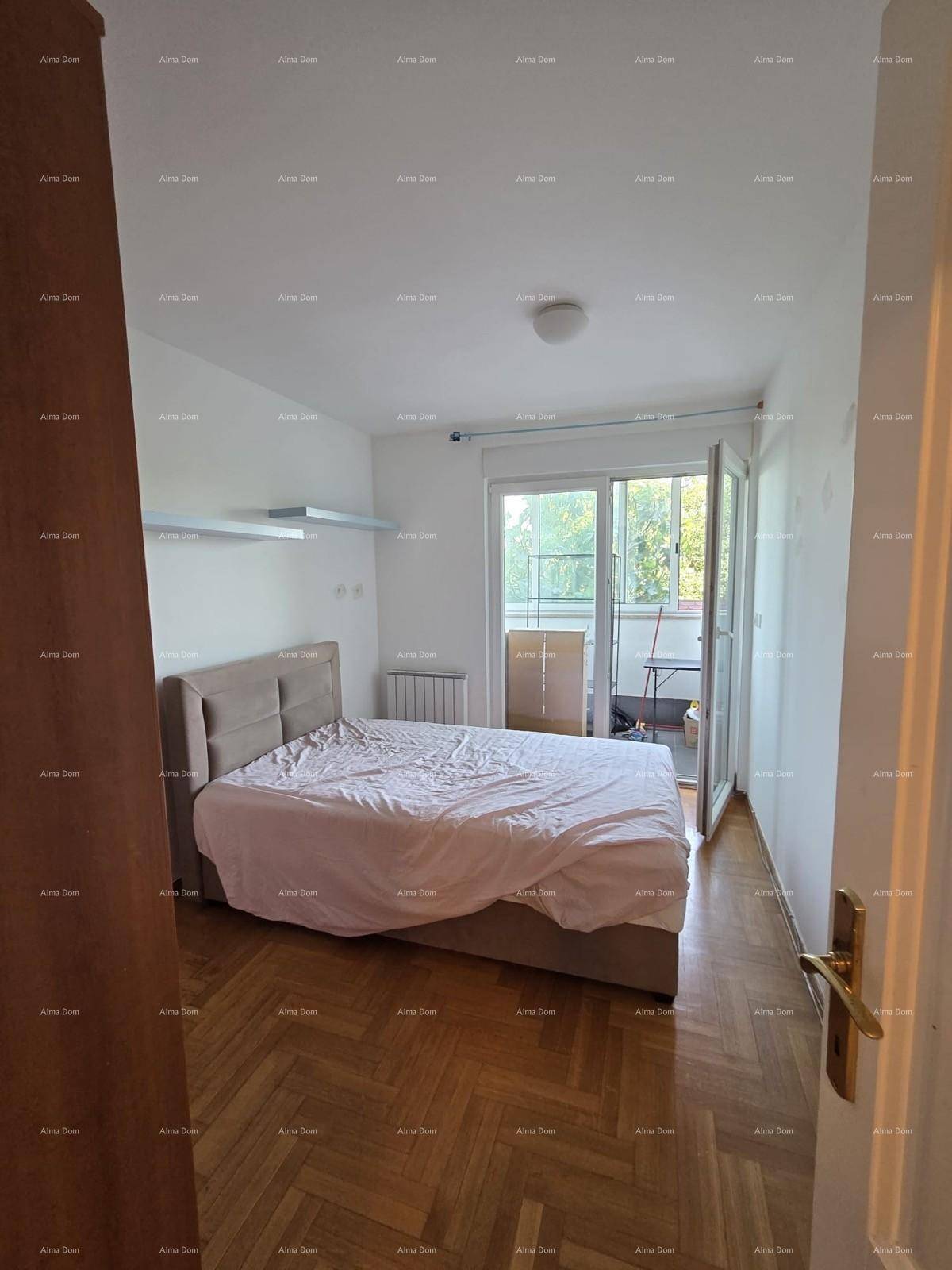 Helles Schlafzimmer mit Parkettboden und direktem Zugang zu einem Balkon.