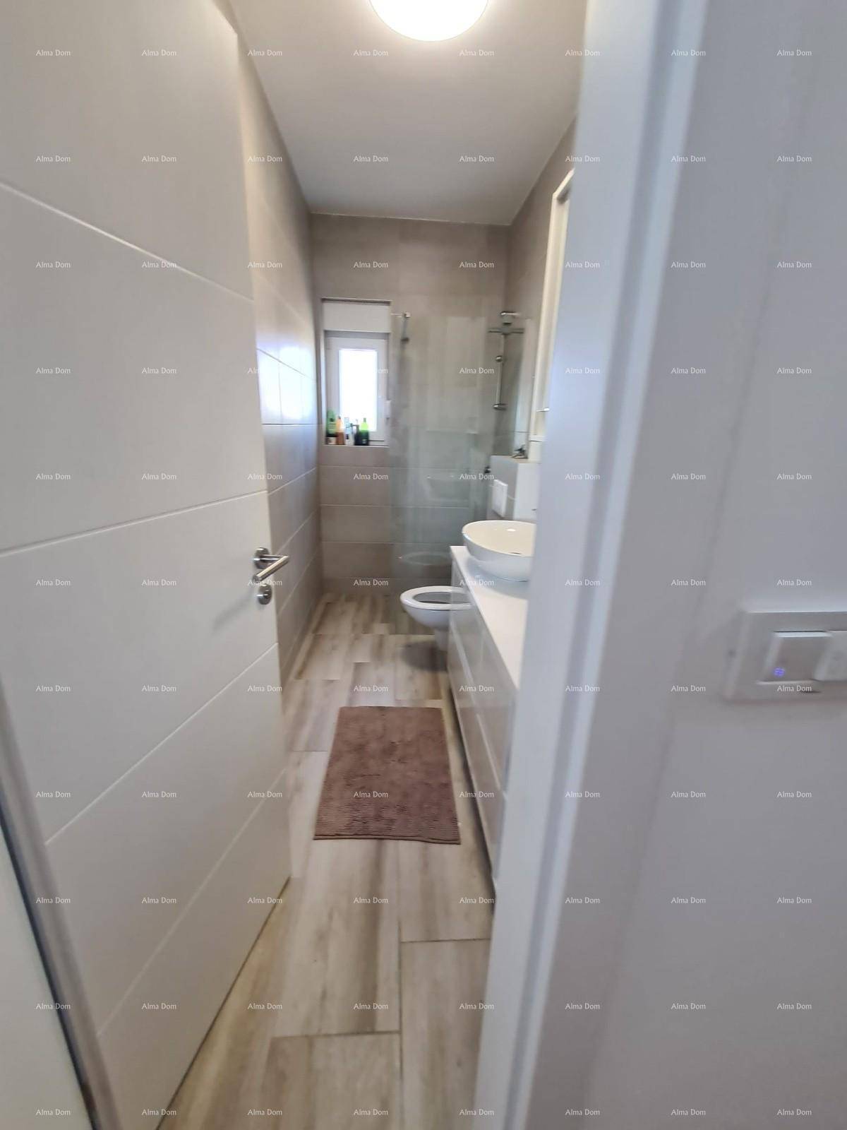 Modernes Badezimmer mit begehbarer Dusche, WC und Waschbecken, komplett gefliest in hellen Tönen.