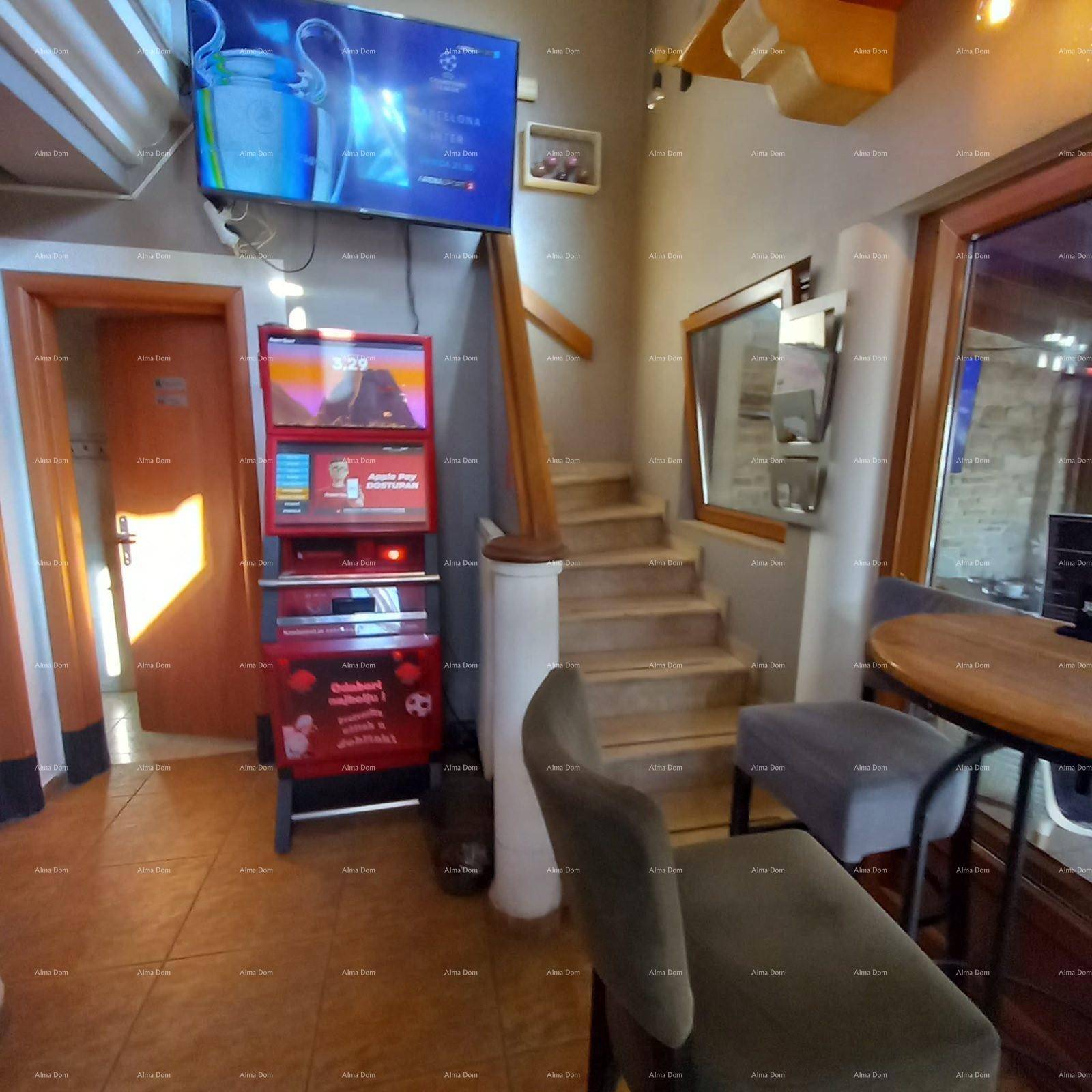 Eingangsbereich mit Holztreppe, Fliesenboden und einem Fernseher an der Wand.