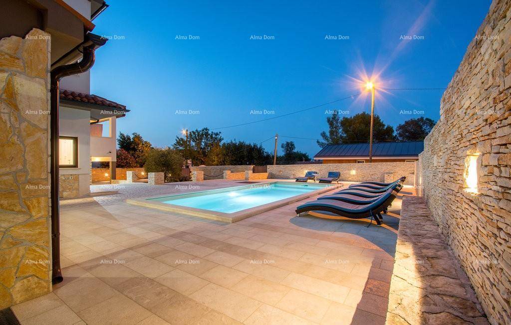 Stimmungsvoll beleuchteter Poolbereich bei Nacht, umgeben von Steinmauern und Terrassenfliesen.