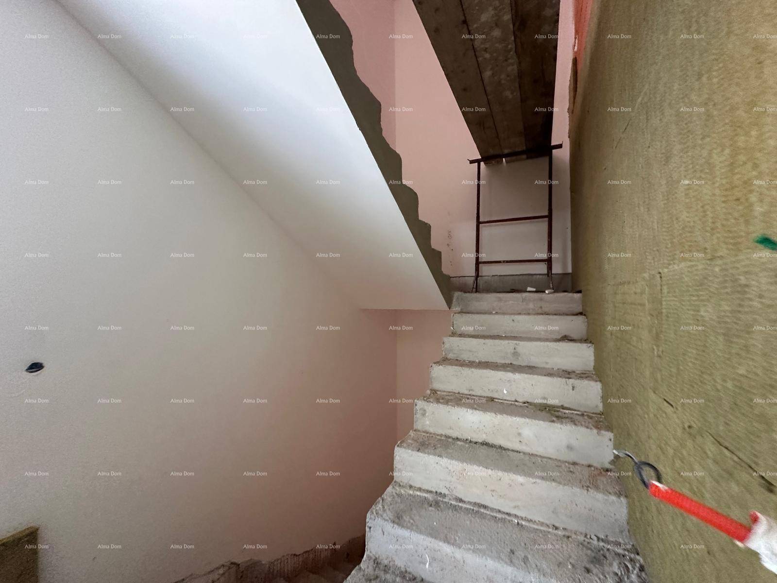 Betontreppe im Rohbau eines Treppenhauses mit teilweise verputzten Wänden und Dämmung.