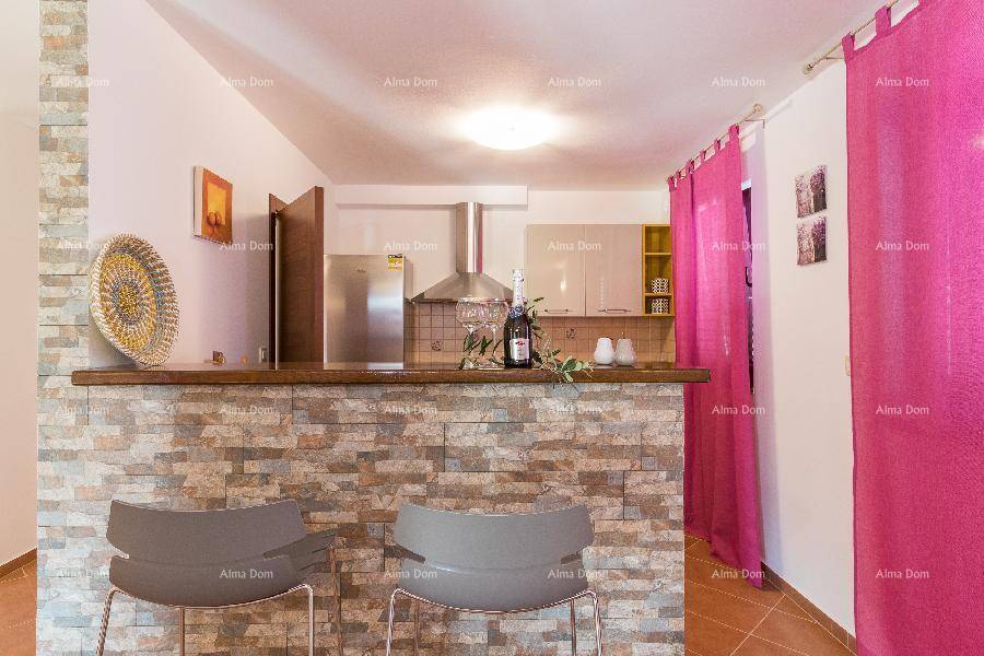 Moderne Küche mit Frühstücksbar, Edelstahlgeräten und lebhaften pinken Vorhängen.
