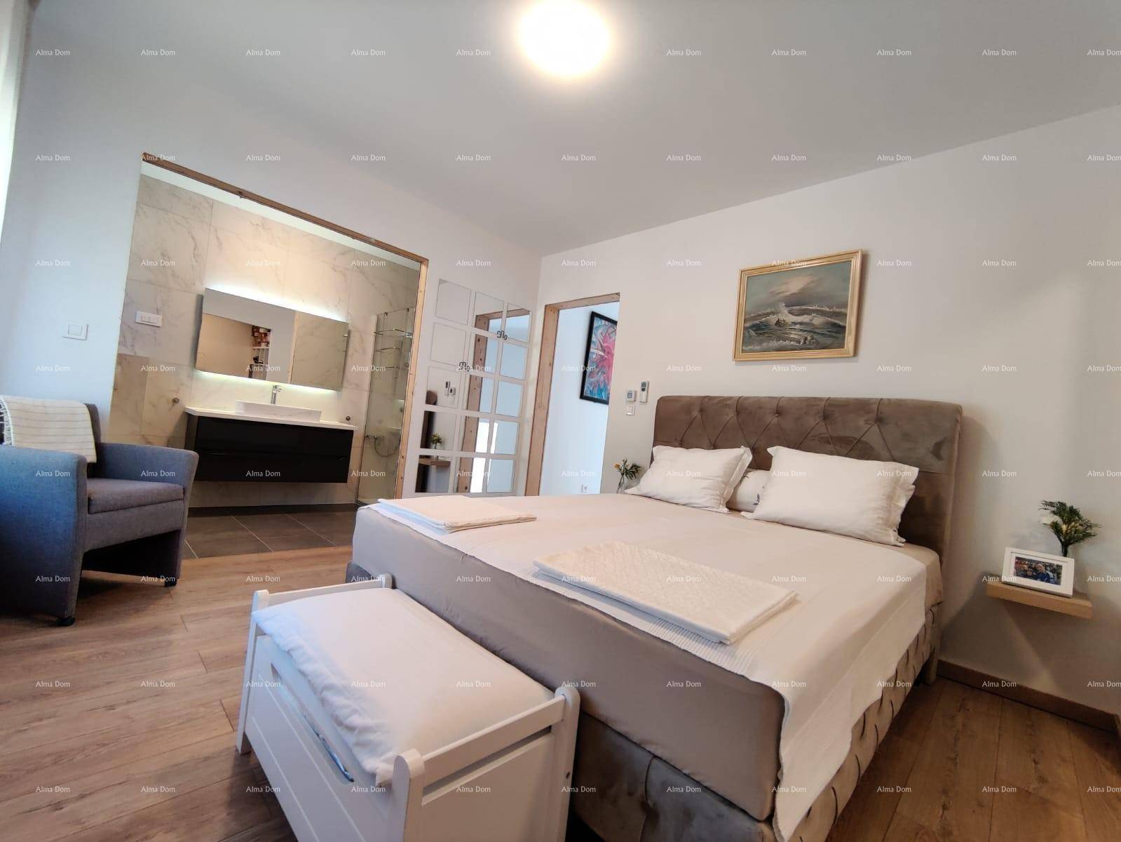 Geräumiges Schlafzimmer mit Holzboden und direktem Zugang zu einem modernen Badezimmer.