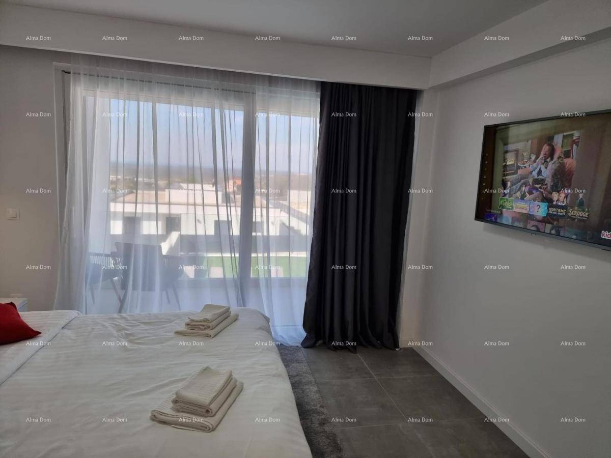 Schlafzimmer mit großem Fenster, eleganten Vorhängen und weitem Blick auf die Umgebung.