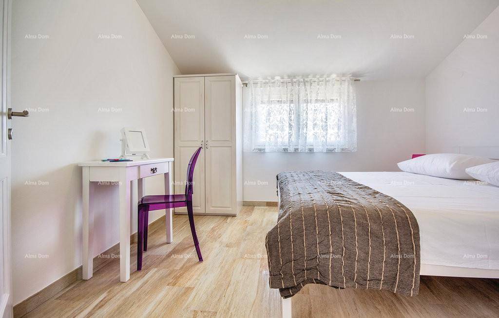 Gemütliches Schlafzimmer mit Dachschräge, Schreibtisch und hellem Laminatboden.