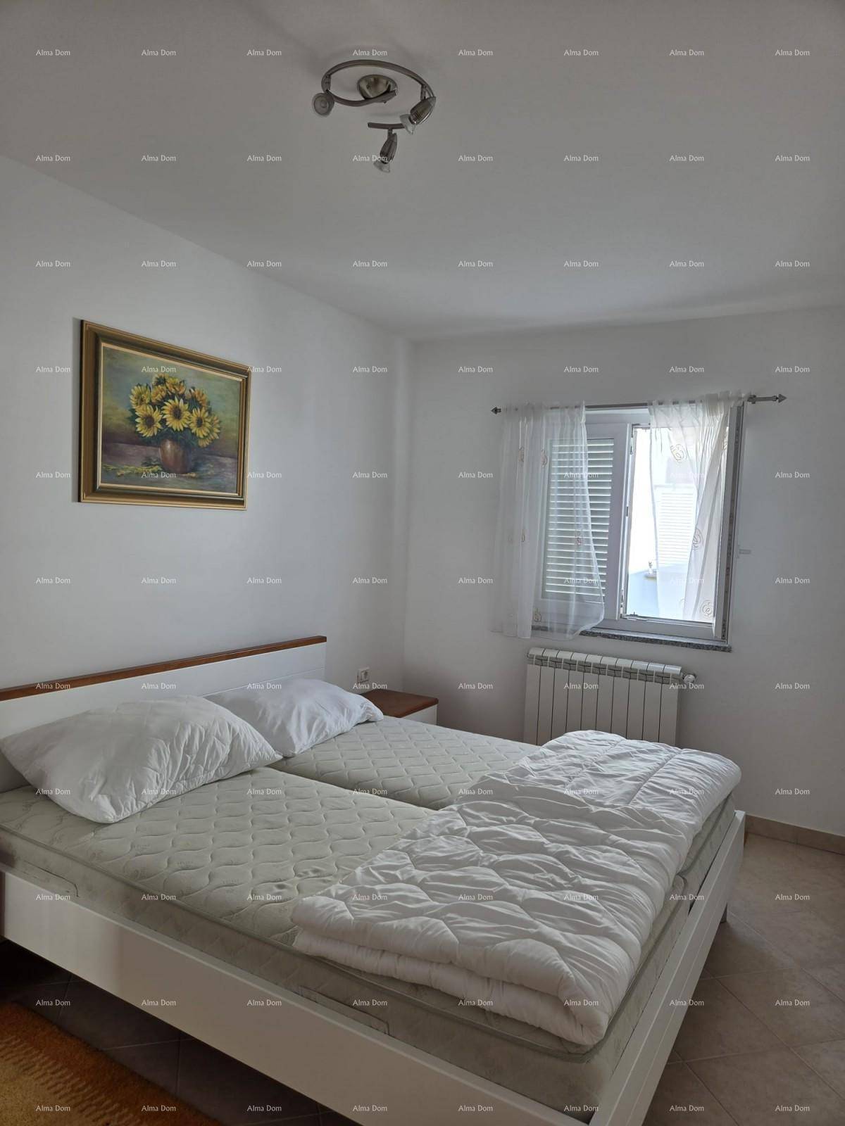 Helles Schlafzimmer mit zwei Einzelbetten, Fenster und Heizkörper, einfach eingerichtet.