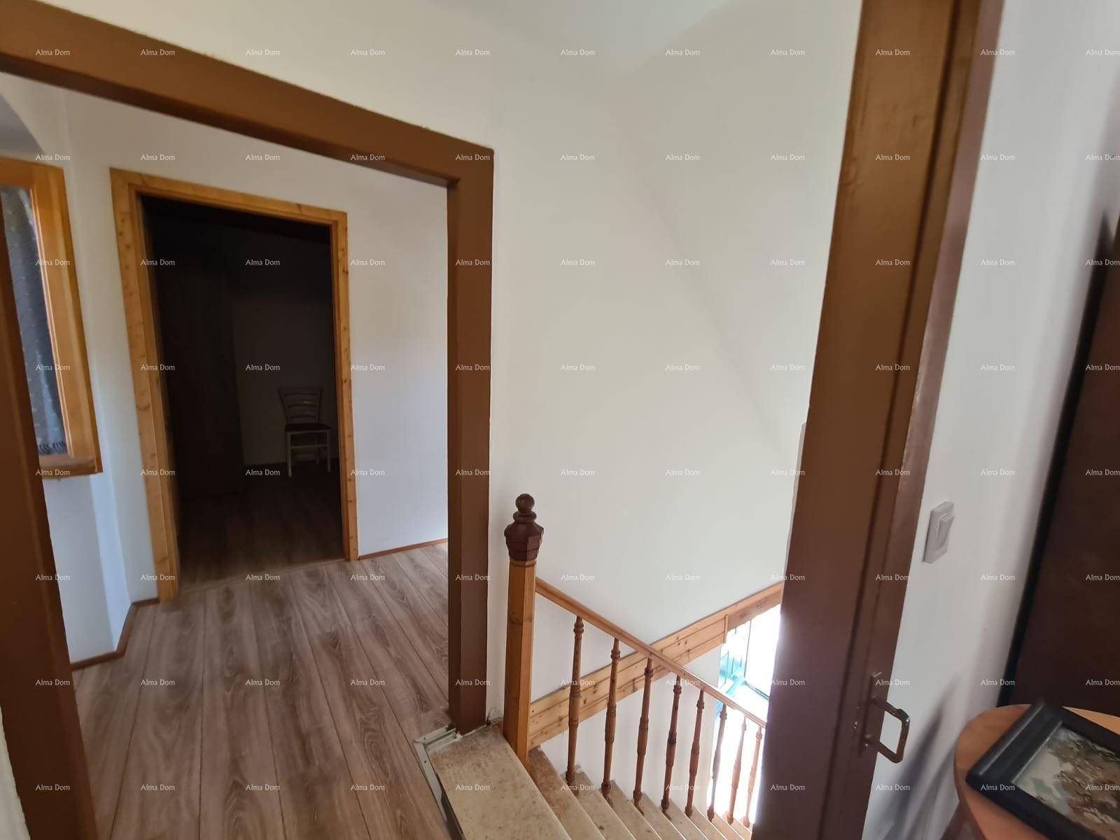 Oberer Flur mit Holzboden und Blick auf die Treppe sowie angrenzende Zimmer mit Holztüren.