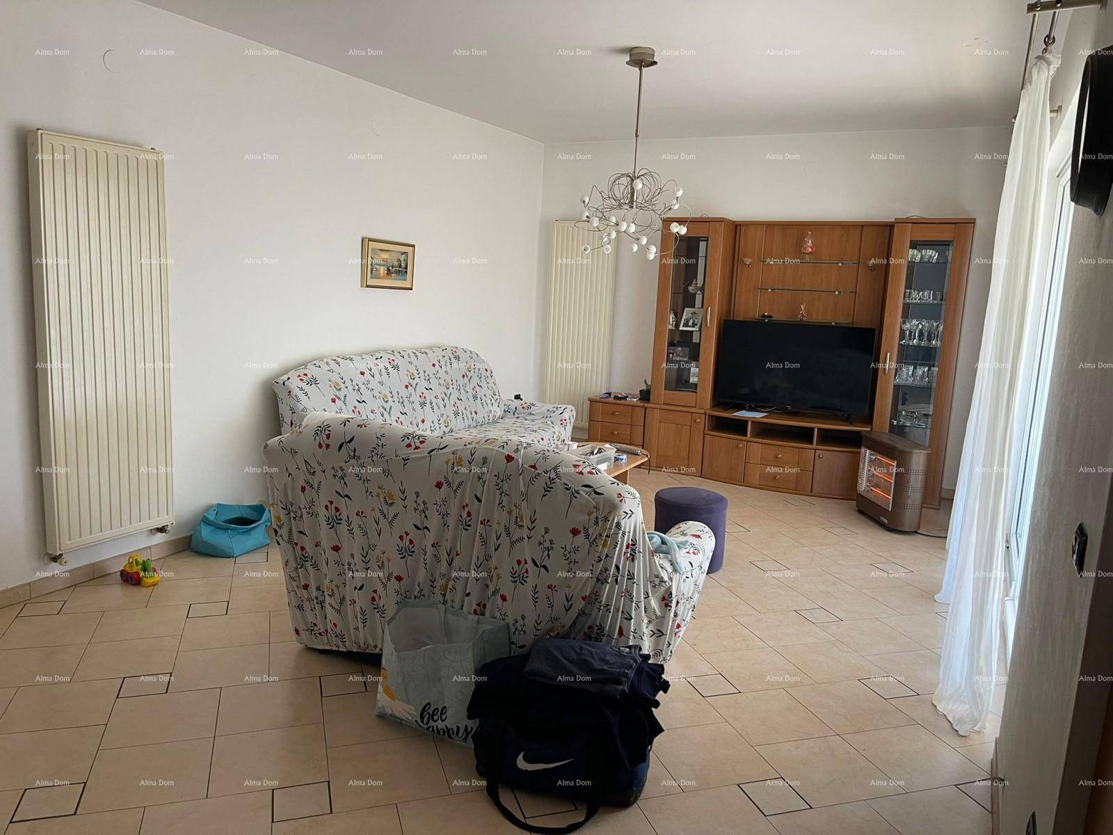 Geräumiges Wohnzimmer mit Fliesenboden, bequemen Sofas und einem TV-Möbel, hell und einladend.