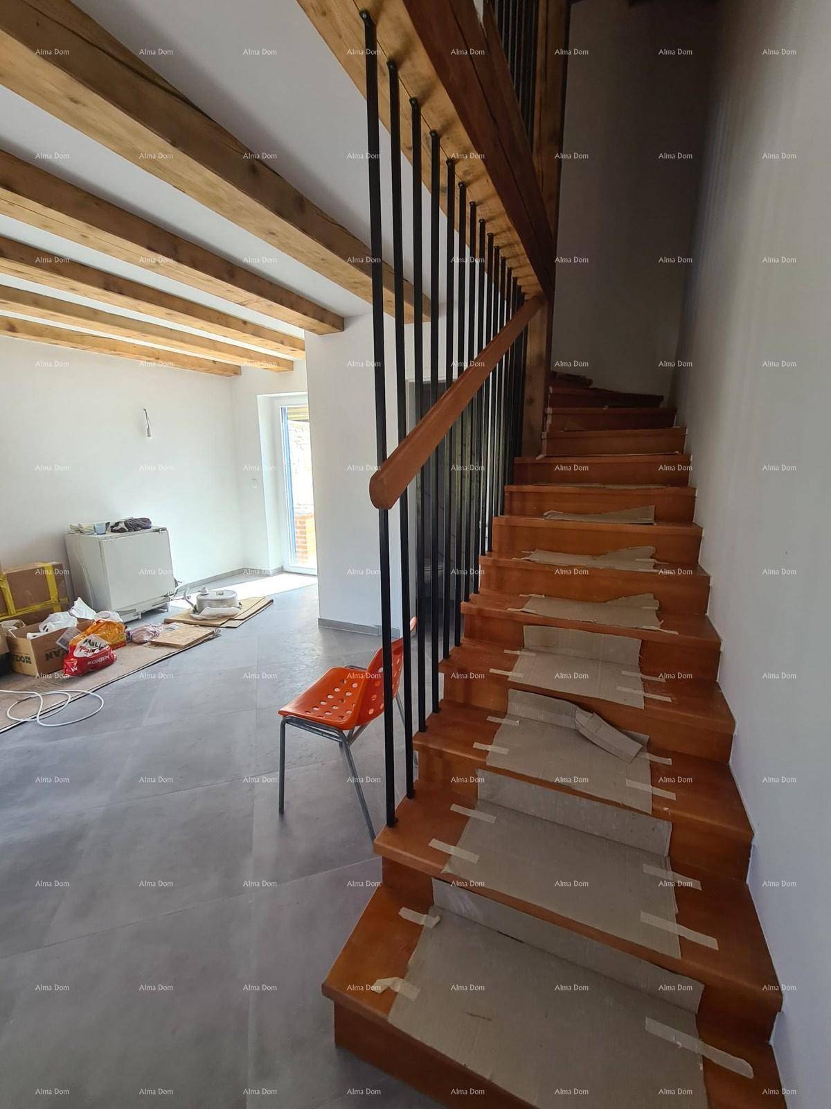 Holztreppe mit schwarzen Metallgeländern, die zu den oberen Etagen führt.