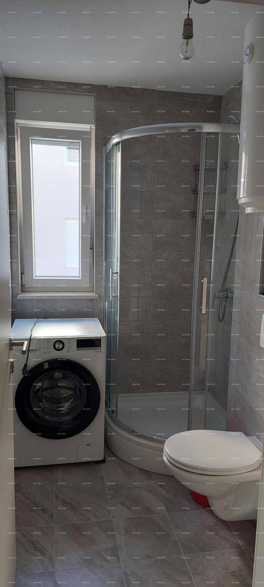 Modernes Badezimmer mit Dusche, wandhängender Toilette, Waschmaschine und Fenster.