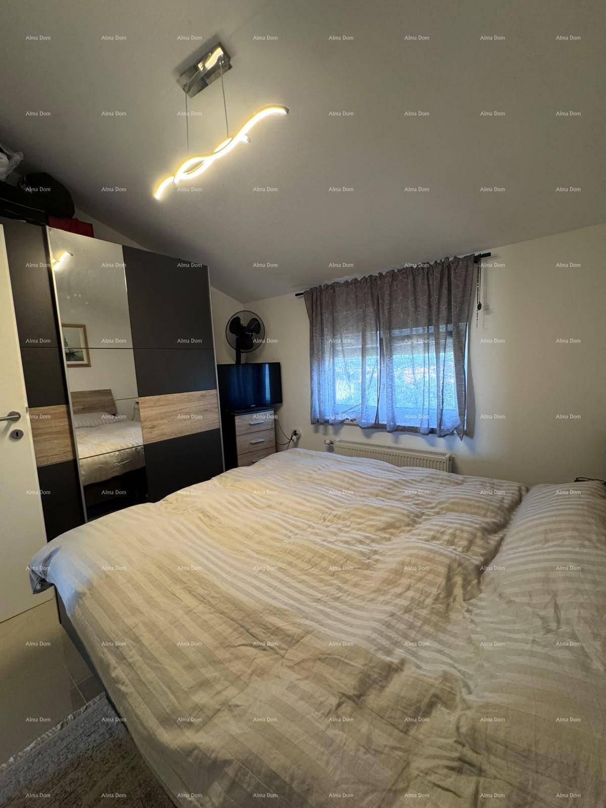 Gemütliches Schlafzimmer mit großem Bett, Spiegelschrank und Fenster unter einer Dachschräge.