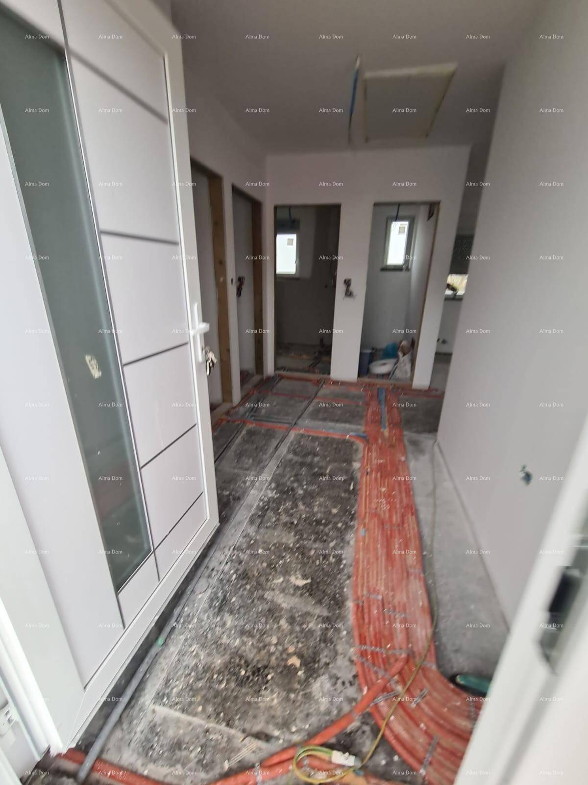 Flur im Rohbau mit sichtbaren Fußbodenheizungsrohren und modernen weißen Innentüren.