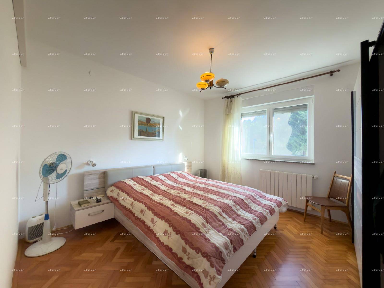 Helles Schlafzimmer mit Doppelbett, Parkettboden und Fenster, ausgestattet mit Ventilator.