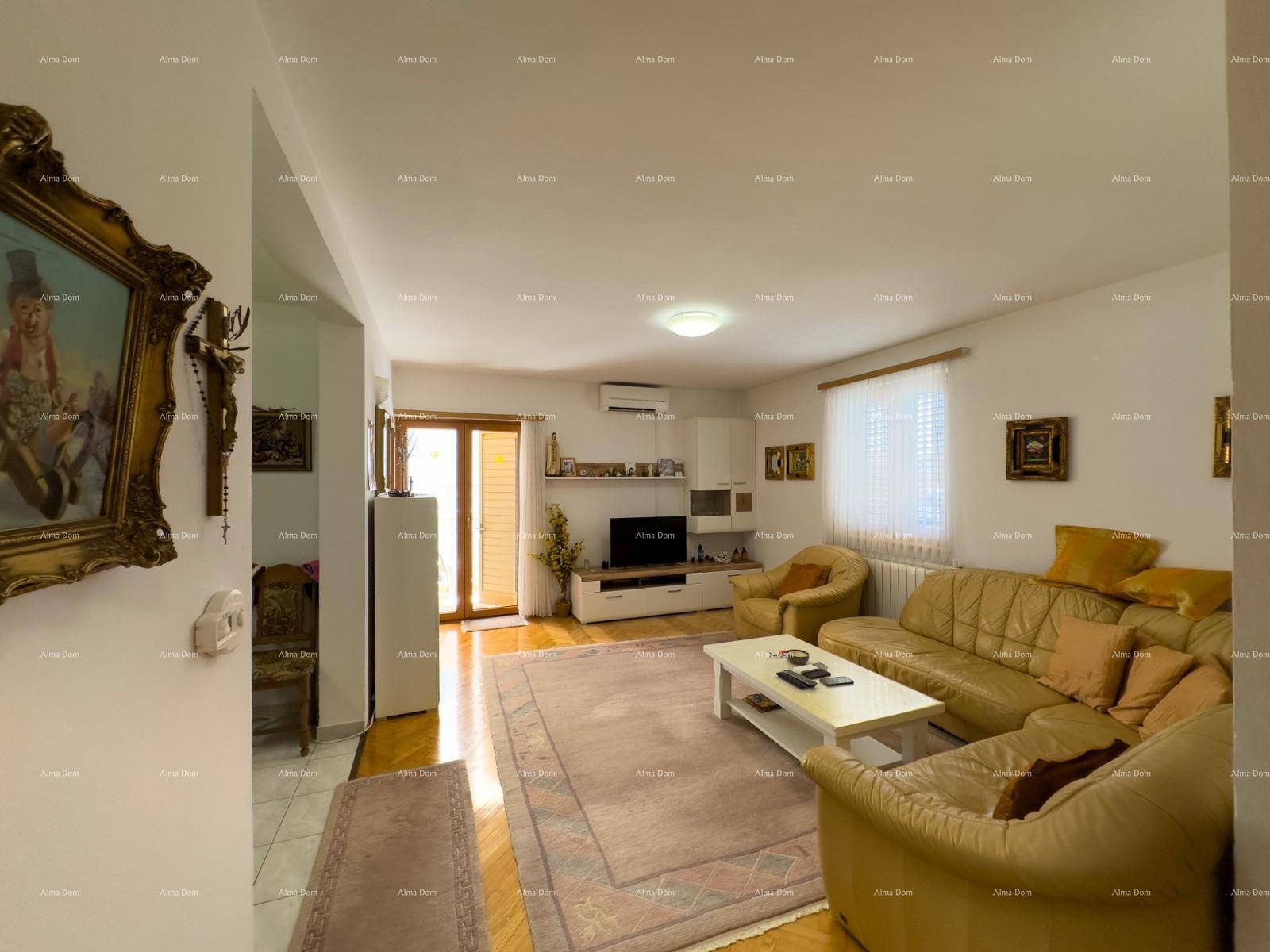 Gemütliches Wohnzimmer mit beiger Ledercouch, Couchtisch und Holzboden.