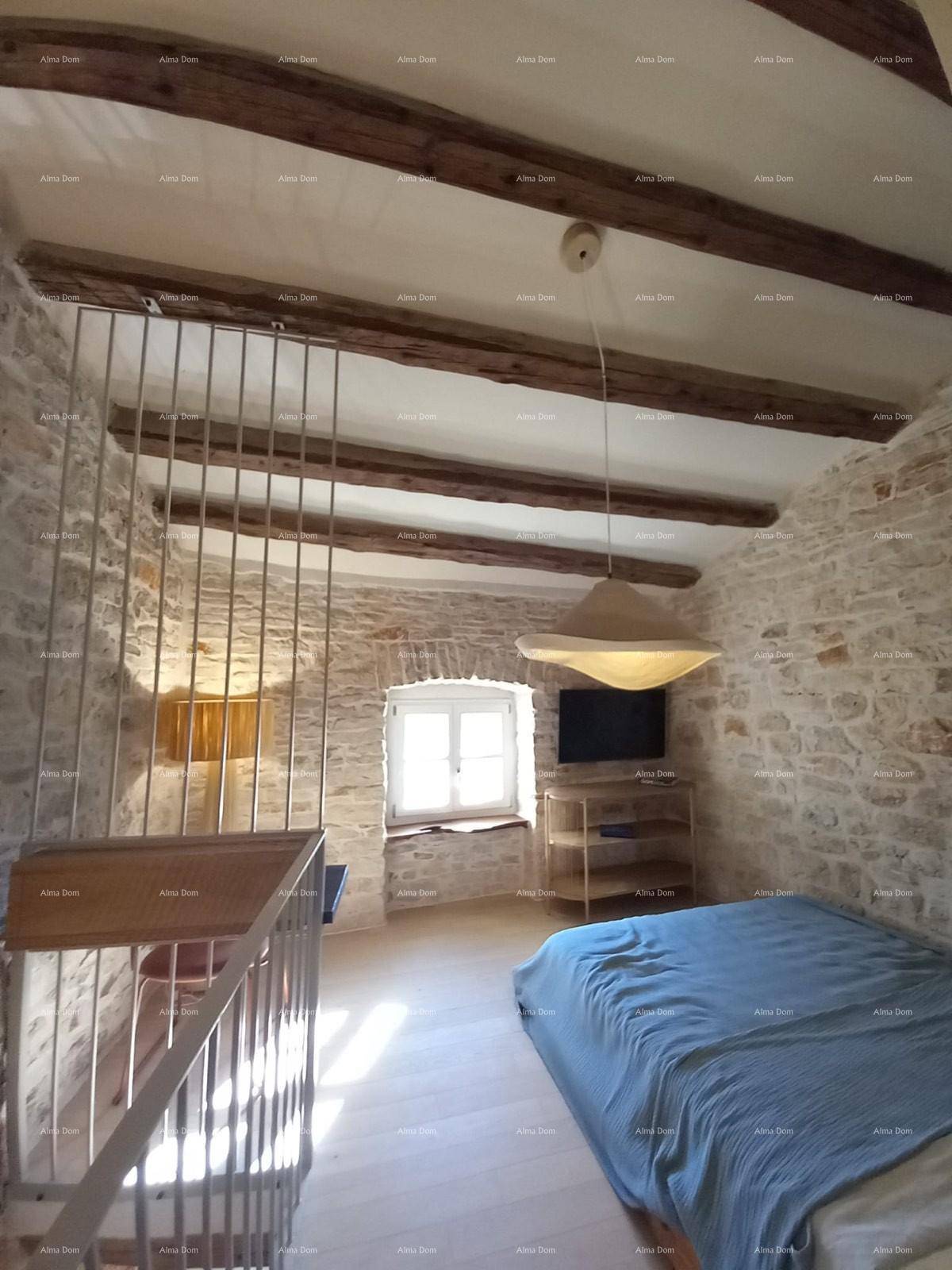 Schlafzimmer im Obergeschoss mit offener Galerie, Steinwänden und Holzbalkendecke.