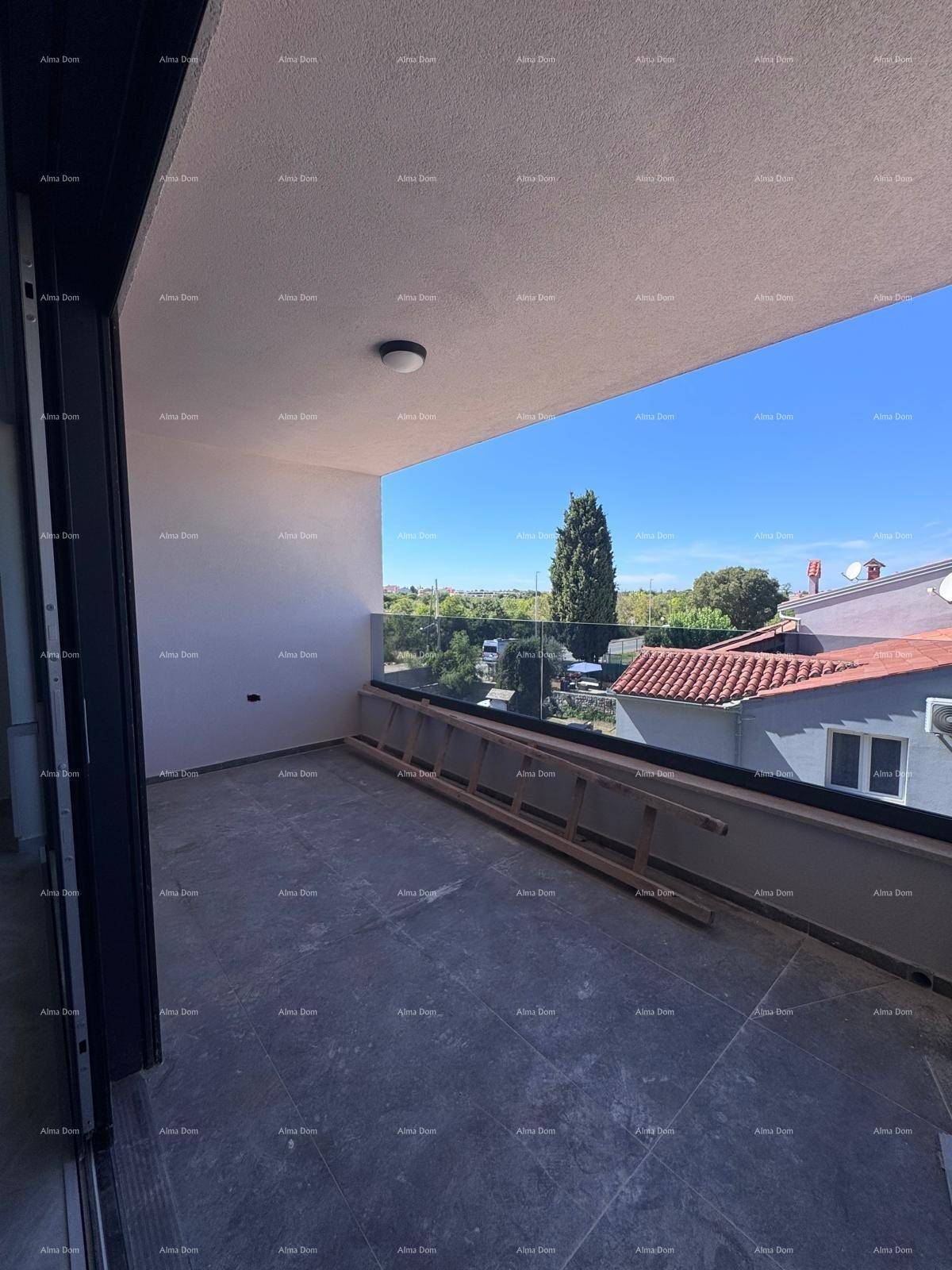 Heller Balkon mit dunklen Fliesen, Glasgeländer und Blick auf die grüne Landschaft.