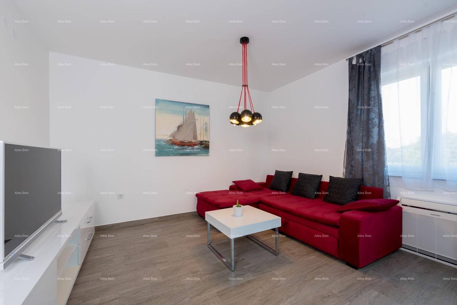 Gemütliches Wohnzimmer mit rotem Sofa, Flachbildfernseher und dekorativem Wandbild.