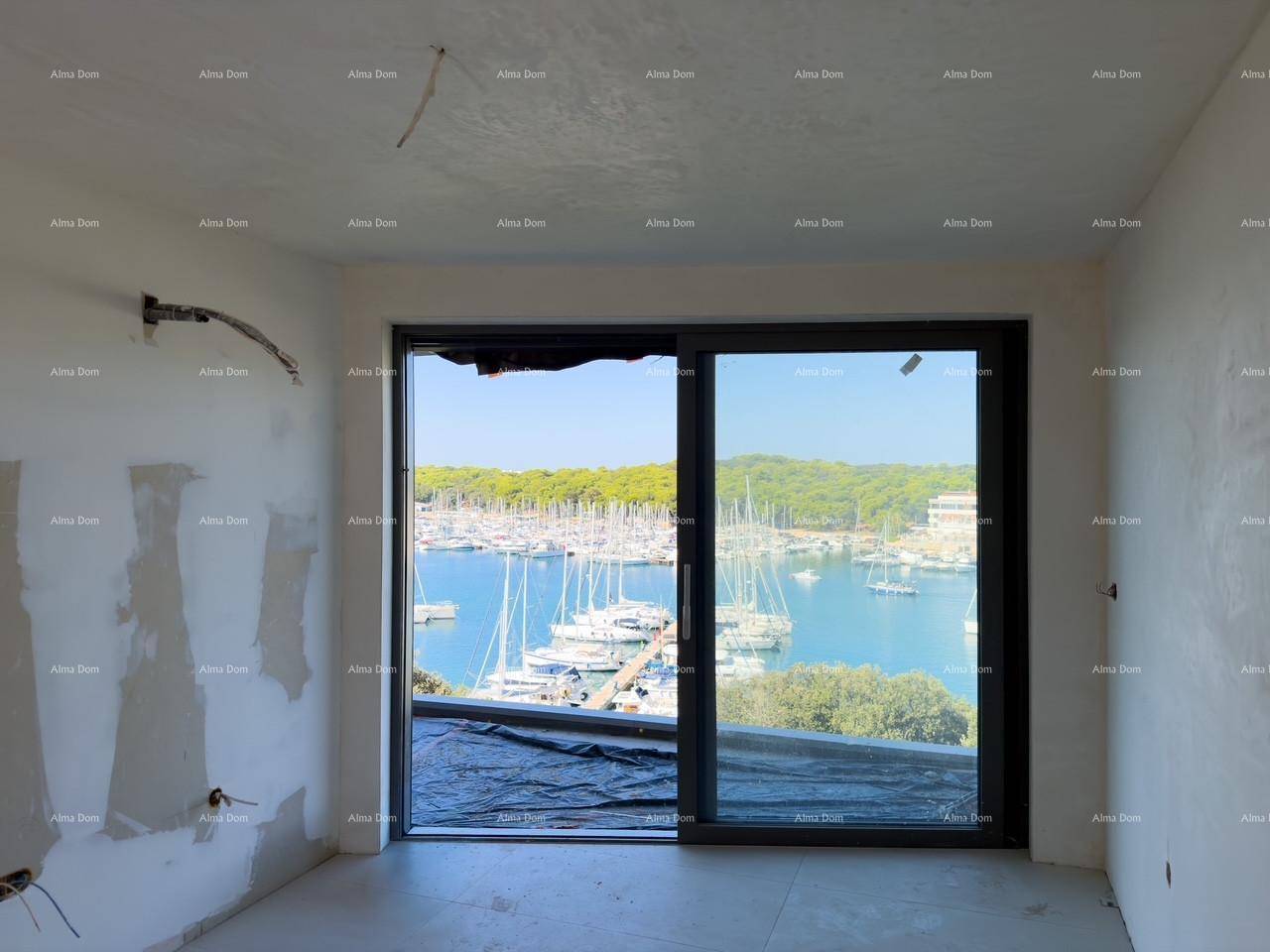 Unfertiger Raum mit großer Glasschiebetür, die einen weiten Blick auf den Yachthafen und das Meer freigibt.
