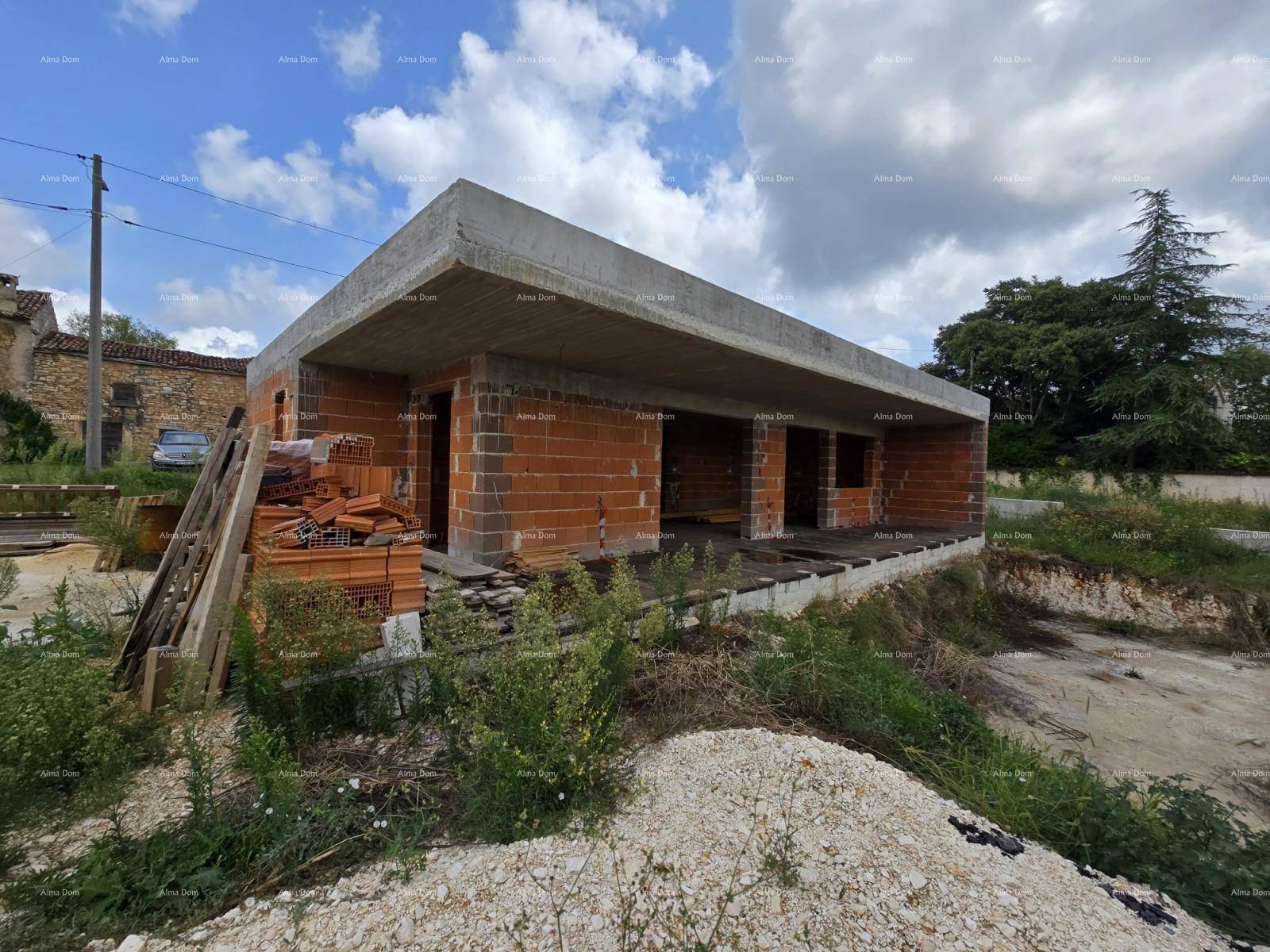 Rohbau einer modernen Villa mit Ziegelwänden und Betonplatte, umgeben von Baustelle und Natur.