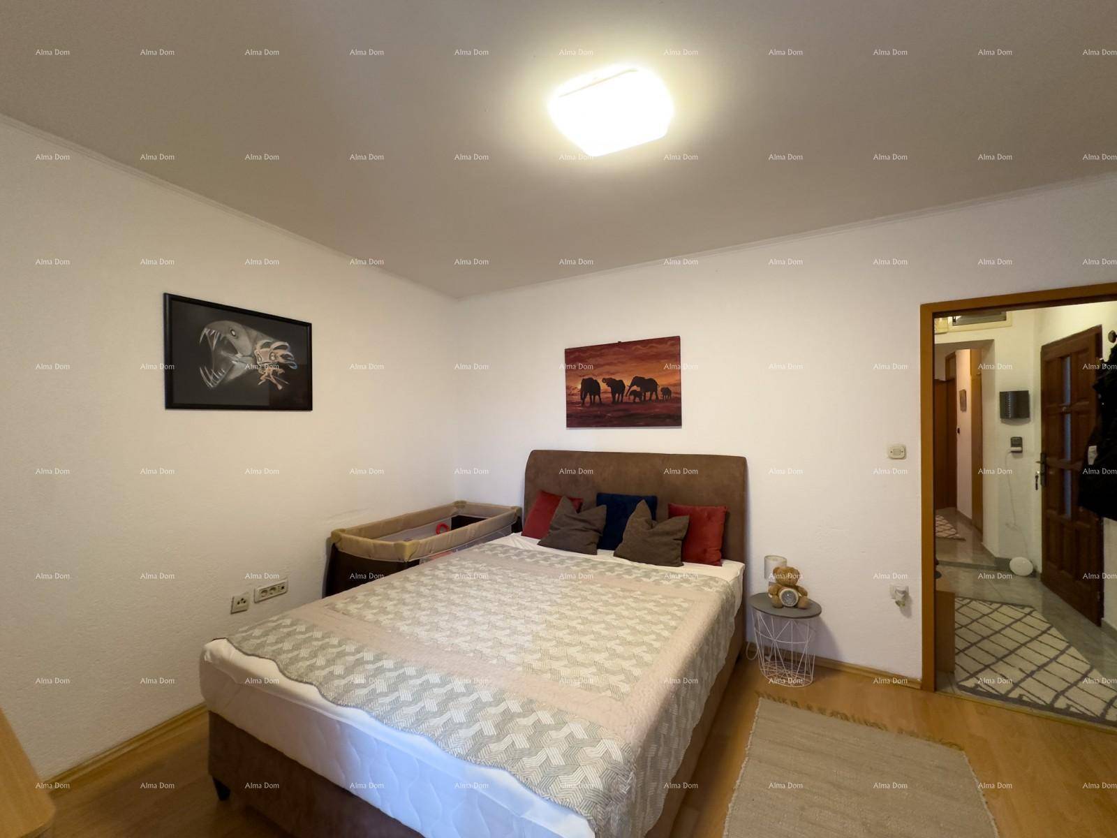 Helles Schlafzimmer mit Doppelbett, Holzboden und Zugang zum Flur.