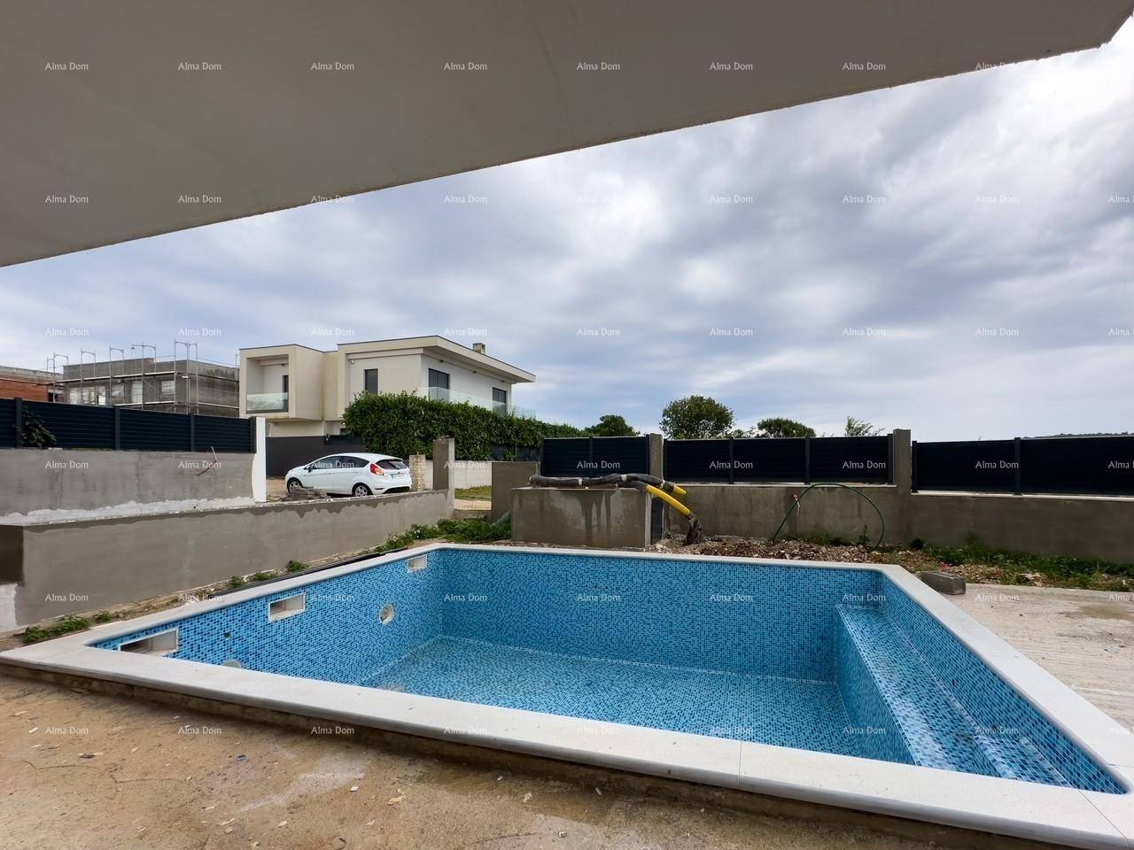 Unfertiger Swimmingpool mit blauen Fliesen im Außenbereich eines modernen Hauses.