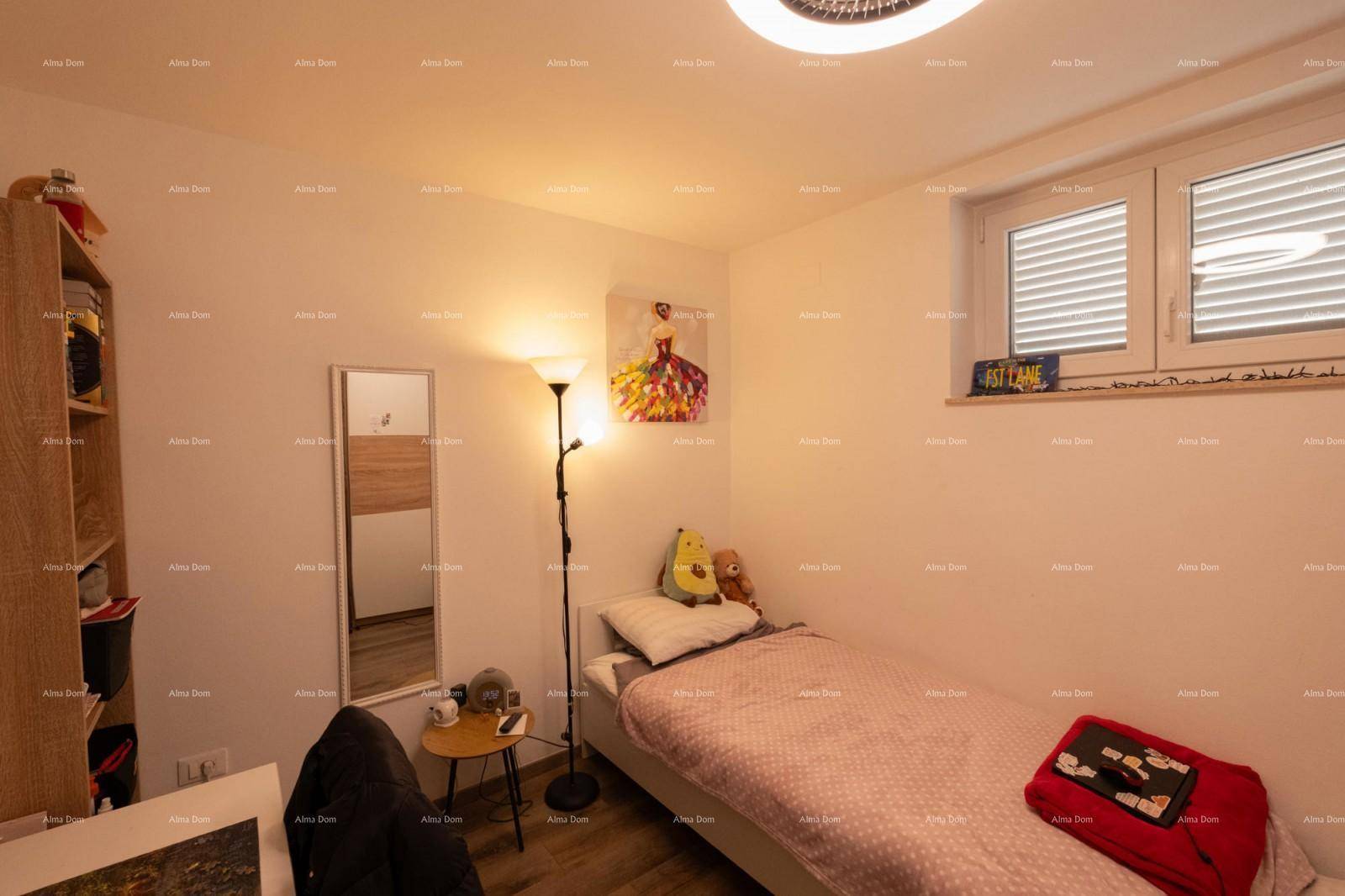 Helles Schlafzimmer mit Einzelbett, Spiegel und Stehlampe.