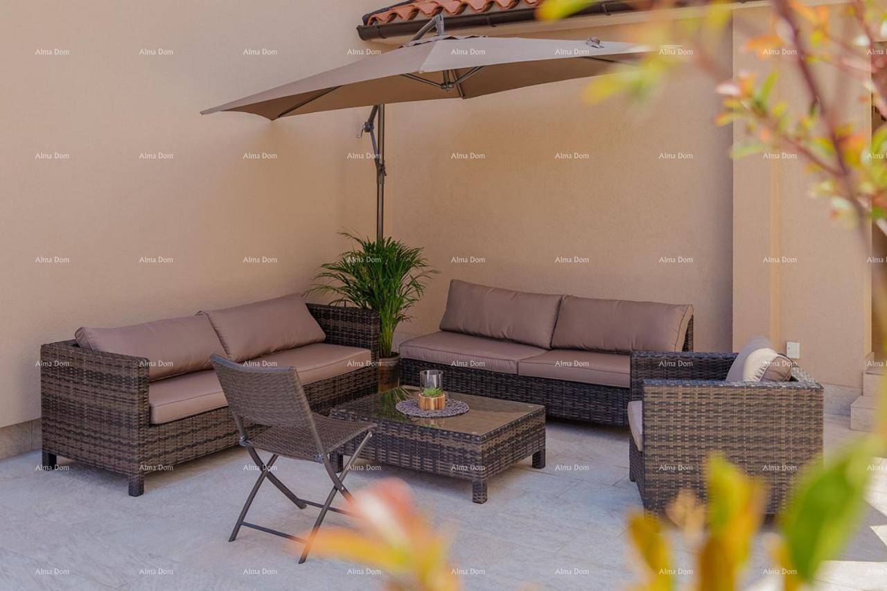 Komfortable Terrasse mit Rattanmöbeln und Sonnenschirm, perfekt zum Entspannen im Freien.
