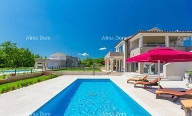 Elegante Villa mit großem, rechteckigem Pool und Liegebereich unter strahlend blauem Himmel.