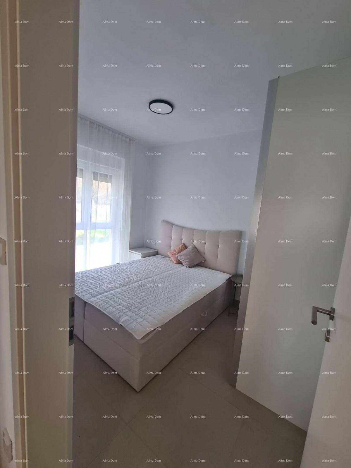 Blick durch einen Türrahmen in ein helles Schlafzimmer mit Doppelbett und Fenster.