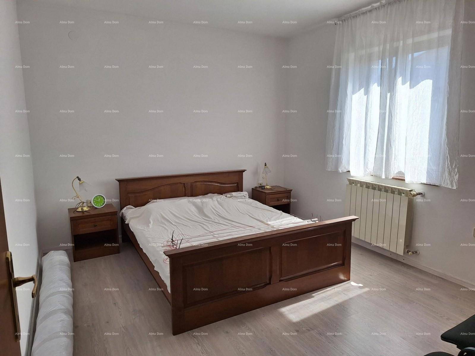 Schlafzimmer mit Holzbett, Nachttischen und hellem Laminatboden.