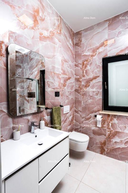 Modernes Badezimmer mit auffälligen rosa-marmorierten Fliesen, Waschtisch und Wand-WC.
