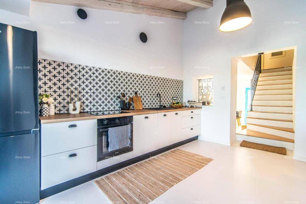 Moderne Küche mit weißen Schränken, Holzarbeitsplatte und gemusterten Fliesen als Spritzschutz.