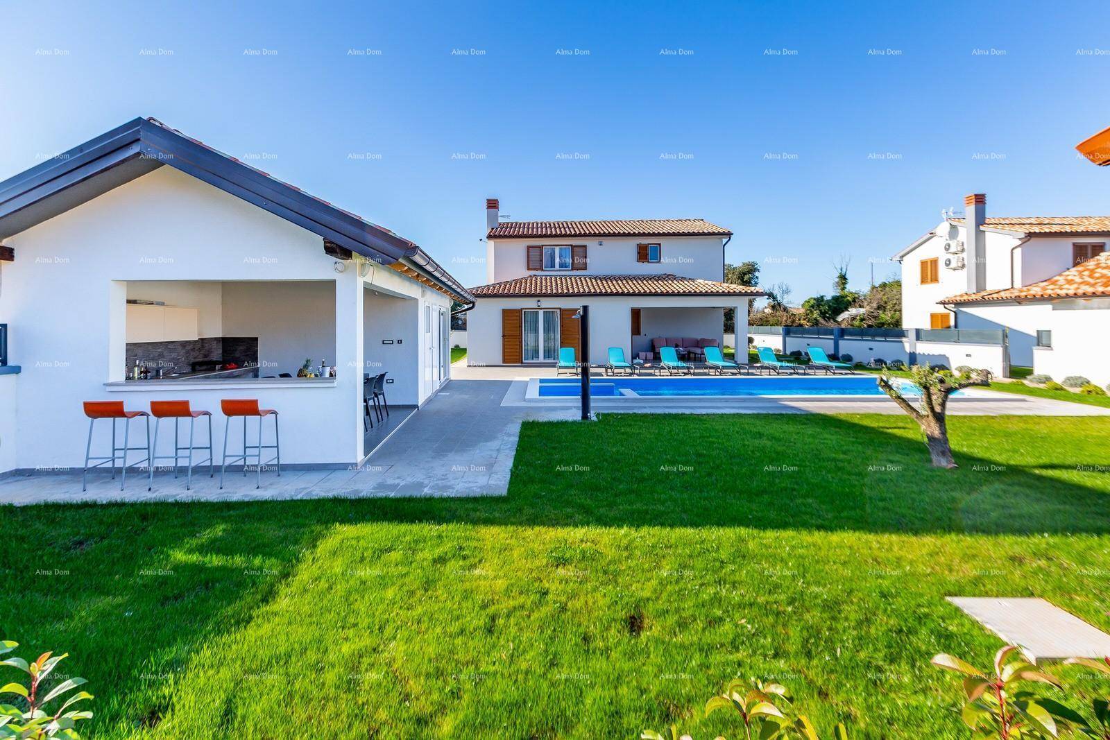 Großer Garten mit Rasenfläche, Pool und einer modernen Außenküche mit Barhockern.