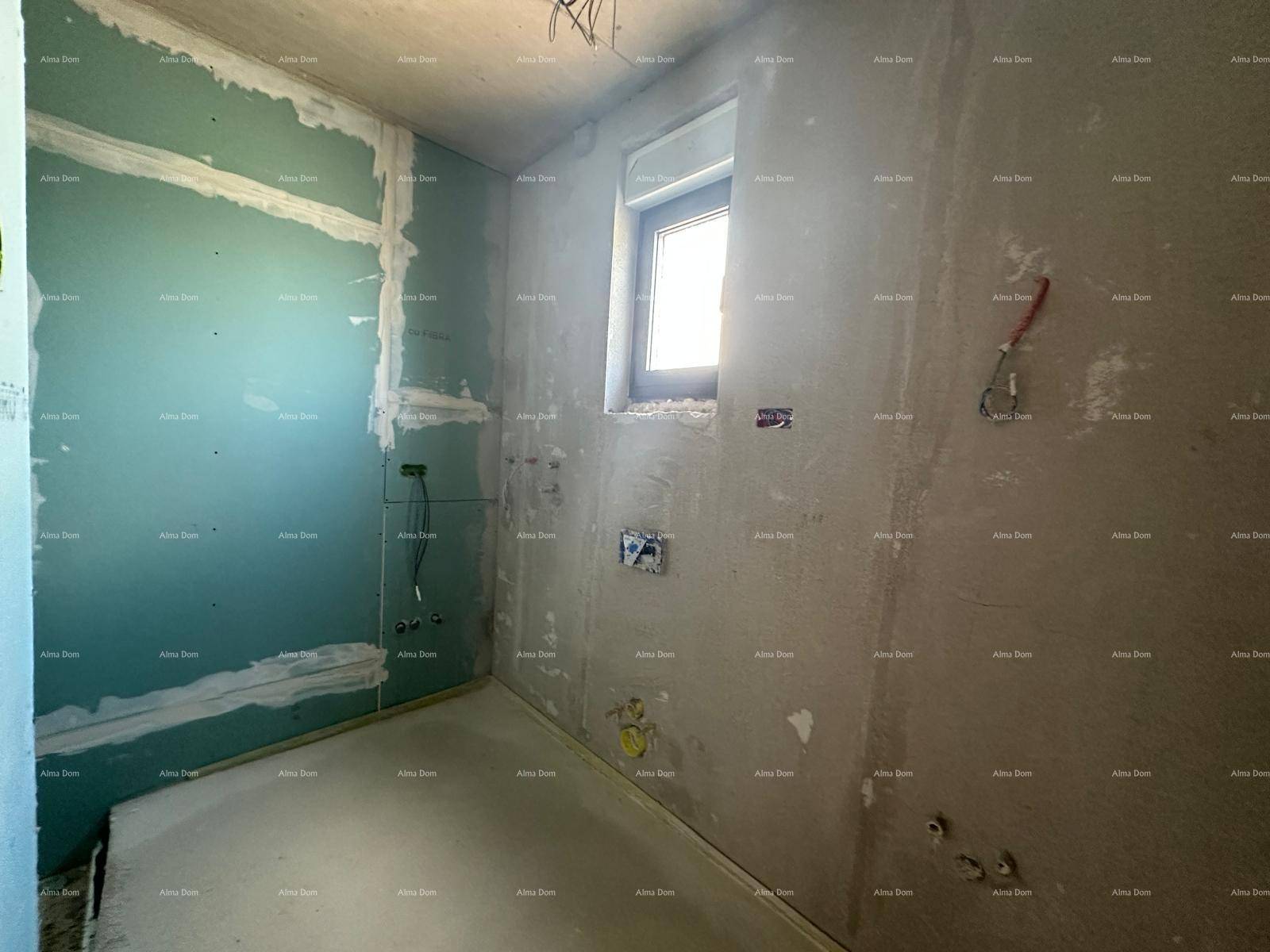 Badezimmer im Rohbau mit Fenster, vorbereiteten Installationen und teilweise verputzten Wänden.