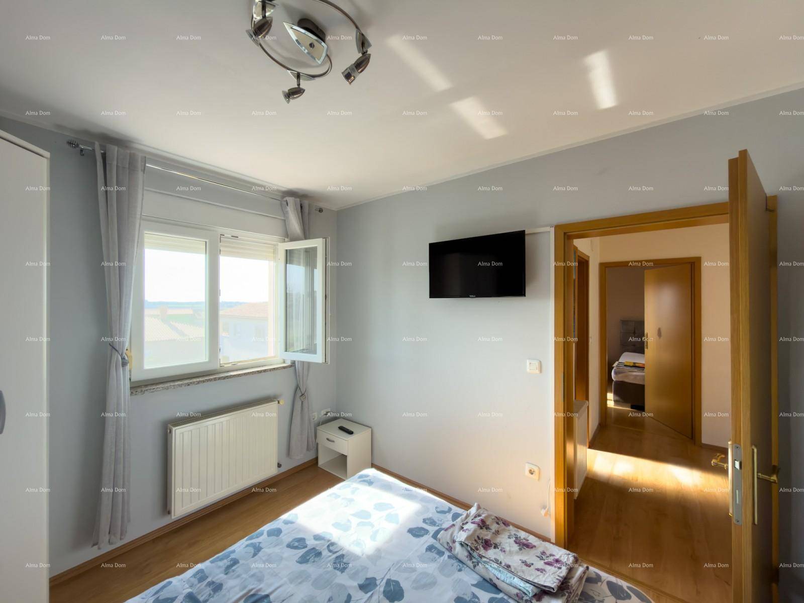 Helles Schlafzimmer mit Doppelbett, Kleiderschrank und Blick nach draußen.