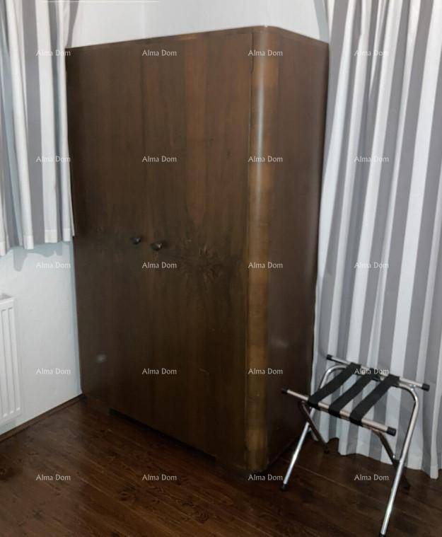 Geräumiger Holzschrank und ein praktischer Gepäckständer in einem Schlafzimmerbereich.