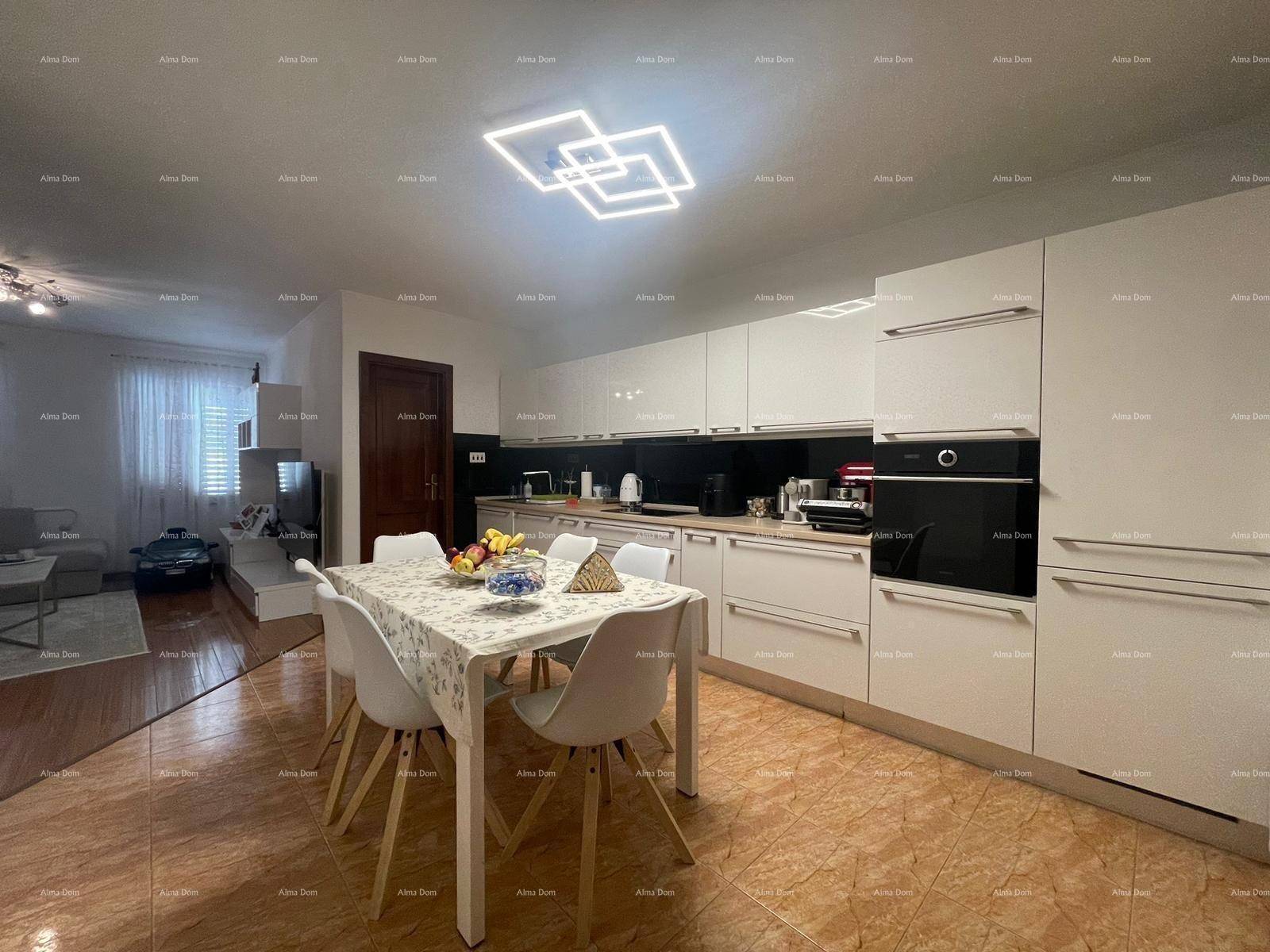 Helle Küche mit weißen Schränken, integrierten Geräten und Essbereich mit modernem Licht.
