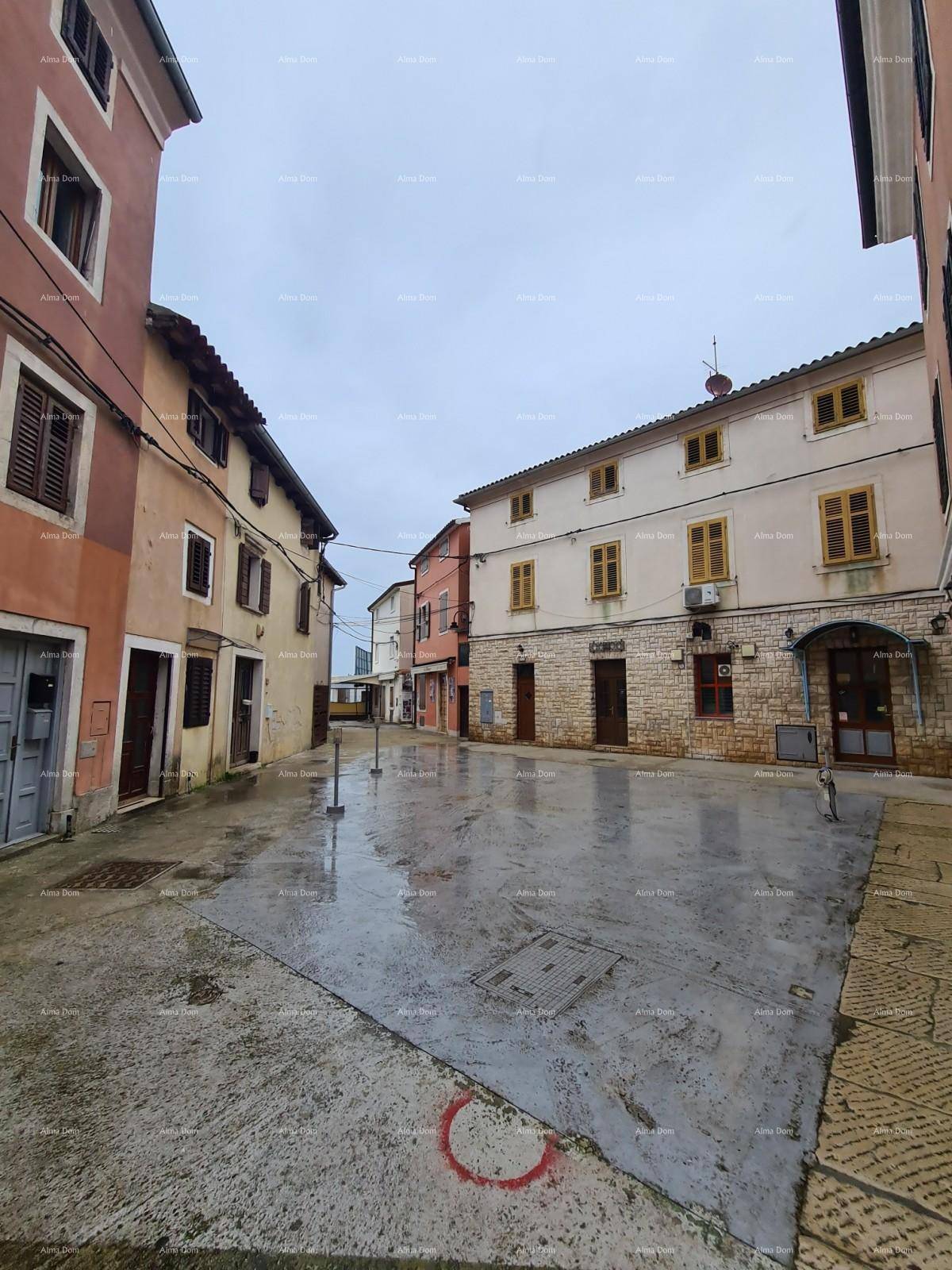 Historische Gasse mit traditionellen Gebäuden und nassem Pflaster nach Regen.