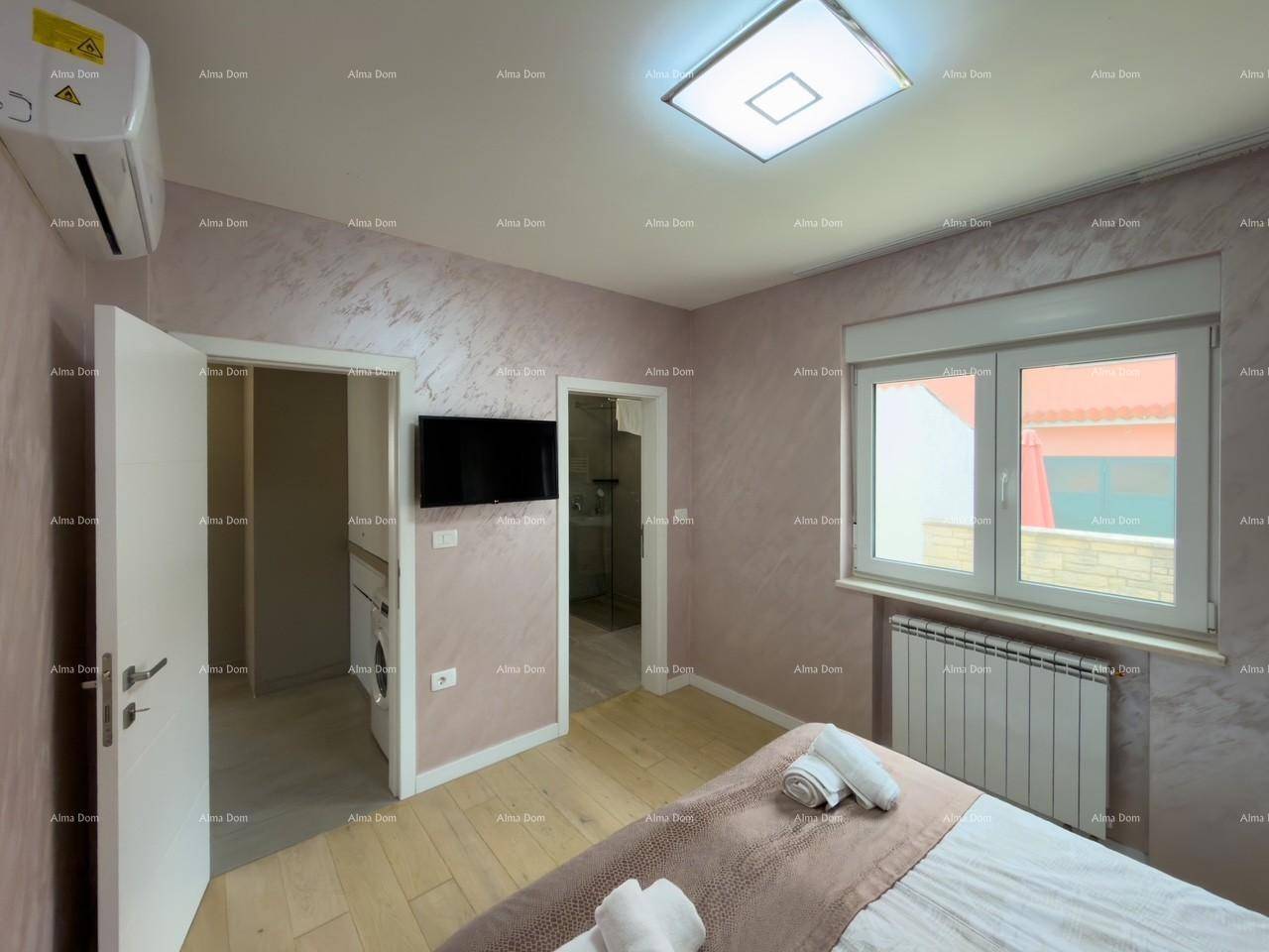 Schlafzimmer mit Klimaanlage, Fernseher und Zugang zu Bad und Flur.