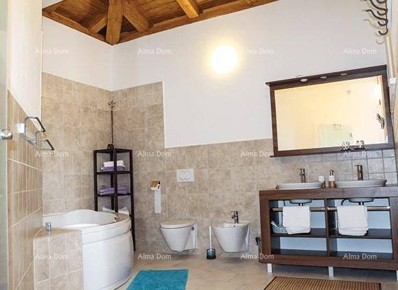 Geräumiges Badezimmer mit Eckbadewanne, Doppelwaschbecken, Bidet und sichtbaren Holzbalken an der Decke.