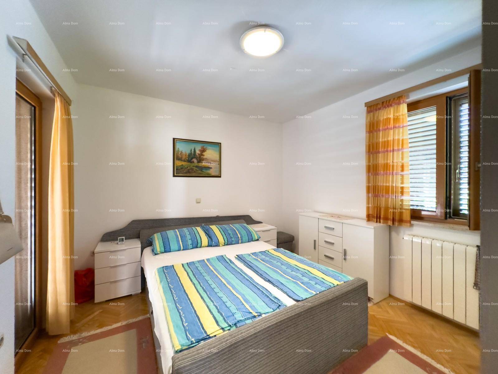Helles Schlafzimmer mit Doppelbett, Nachttischen und Fenster mit bunten Vorhängen.