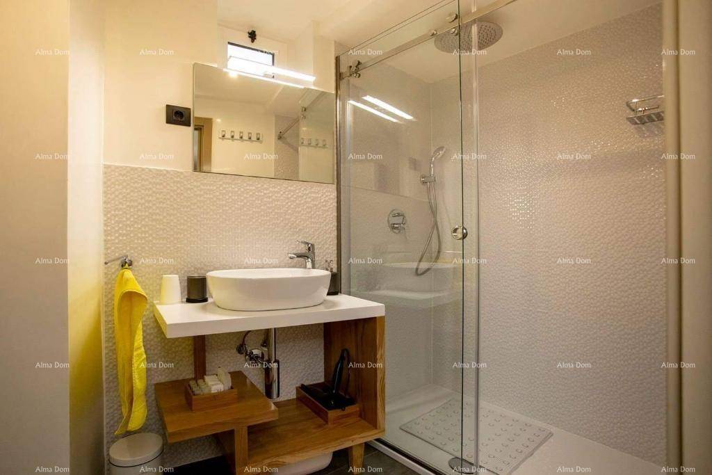 Modernes Badezimmer mit begehbarer Dusche, stilvollem Waschbecken und weißen strukturierten Fliesen, sehr gepflegt.