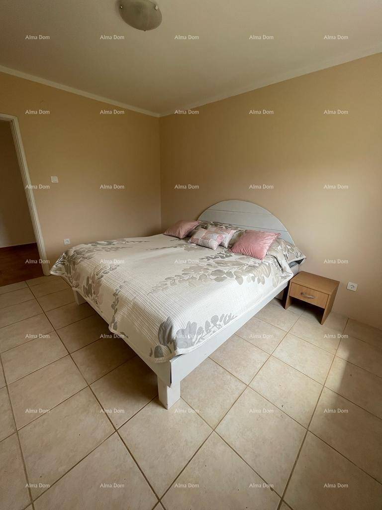 Schlafzimmer mit Doppelbett, Nachttisch und beigen Fliesen, bietet eine ruhige Atmosphäre.