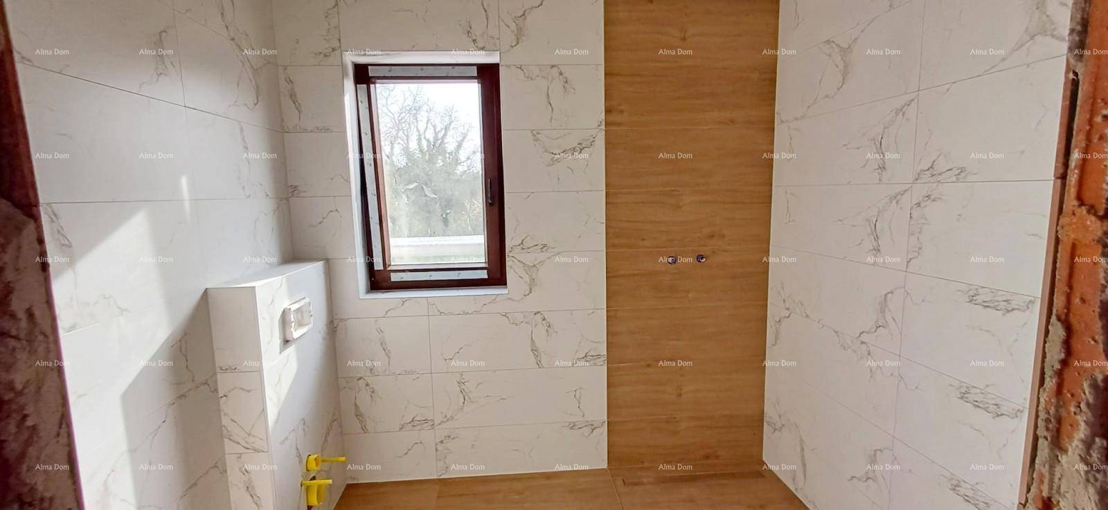 Langer Flur im Obergeschoss mit Holzboden und schrägen Decken, noch im Rohbau.