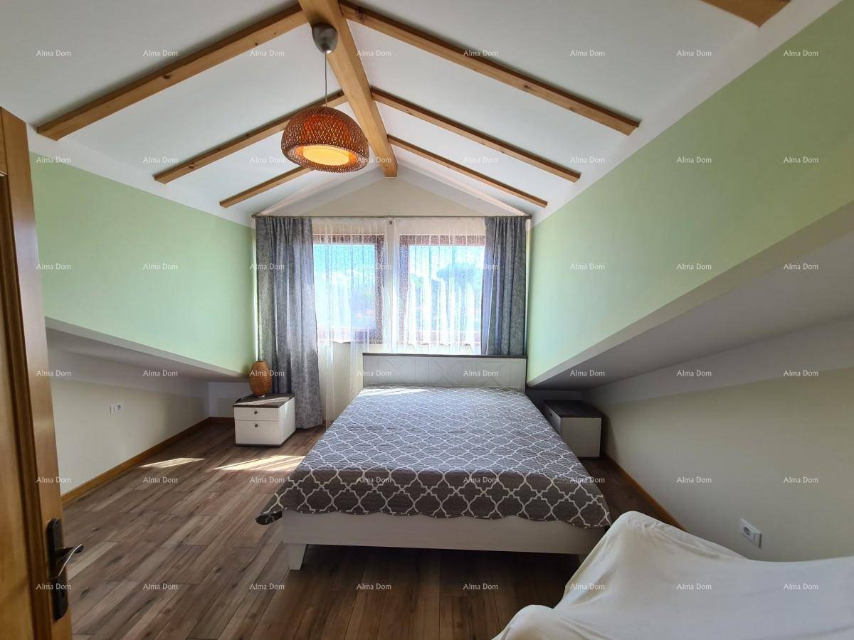 Helles Schlafzimmer im Dachgeschoss mit Holzbalken, schrägen Wänden und Laminatboden.