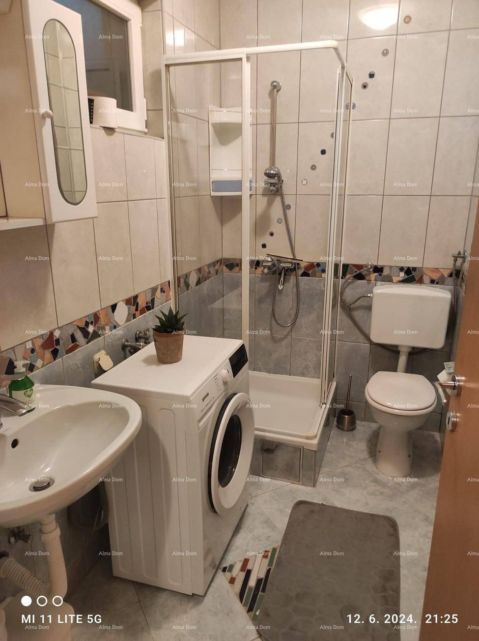 Badezimmer mit Duschkabine, Toilette, Waschbecken und Waschmaschine, funktional und hell.