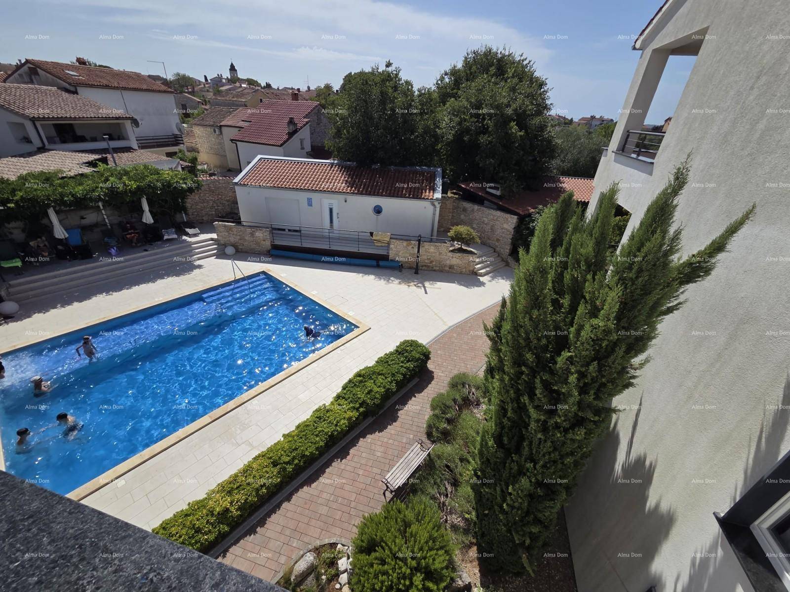 Vogelperspektive auf den Poolbereich mit Schwimmern und umliegenden Gebäuden.