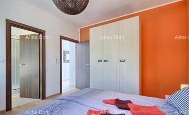 Schlafzimmer mit orangefarbener Wand, großem Kleiderschrank und Zugang zum Badezimmer.