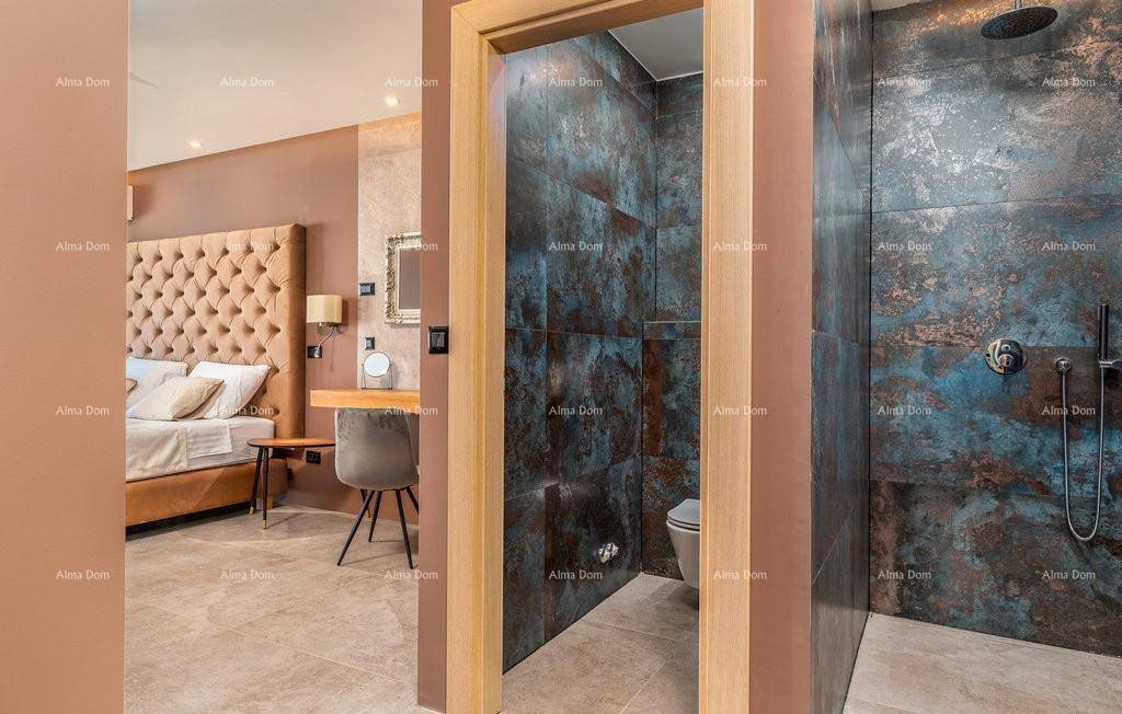 Modernes Badezimmer mit dunklen, strukturierten Fliesen und separatem WC-Bereich, offen zum Schlafzimmer.